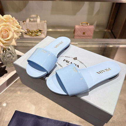PRADA 26S LOGO EMBOSSED SLIDE SANDALS IN SKY BLUE PATENT CALFSKIN