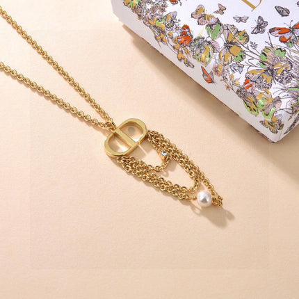CD 26S PEARL CHAIN DROP LOGO NECKLACE IN GOLD TONE METAL WITH WHITE RESIN PEARL & CRYSTAL 631060
